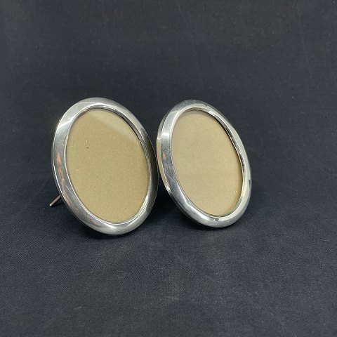 A pair of oval picture frames in silver