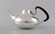 Georg Jensen. Tea pot in sterling silver # 1017.
With handles in guayacan tree.
Drawn by Henning Koppel (1918-1981) in 1956.