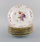 Otte antikke Meissen tallerkener i porcelæn med håndmalede blomster og guldkant. 
Ca. 1900.

