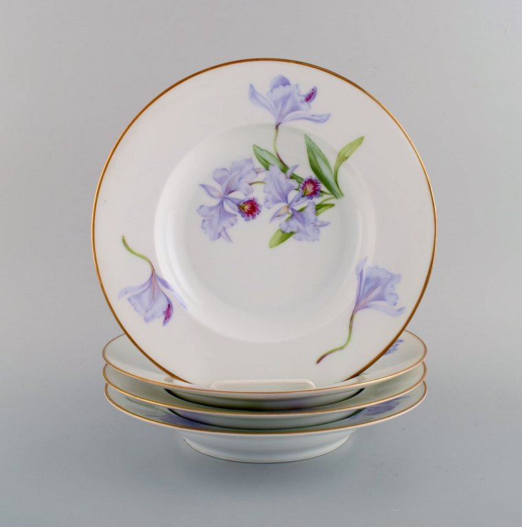 Fire antikke Royal Copenhagen dybe tallerkener i porcelæn med håndmalede 
blomster og guldkant. Tidligt 1900-tallet. 
