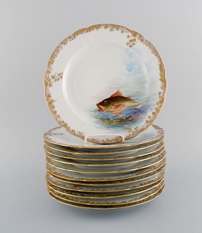 Tolv antikke Pirkenhammer middagstallerkener i porcelæn med håndmalede fisk og 
gulddekoration. Høj kvalitet, tidligt 1900-tallet.
