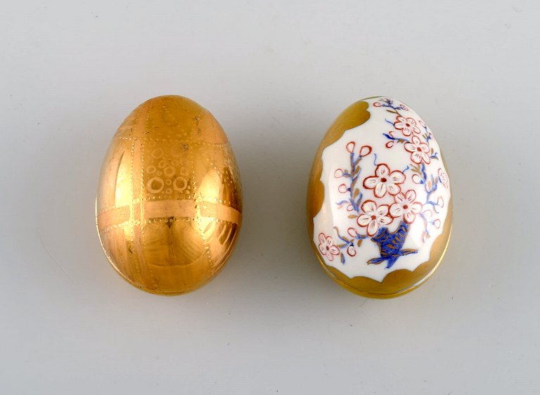 To påskeæg i porcelæn med håndmalede blomster og gulddekoration. Svensk design, 
dateret 1981.
