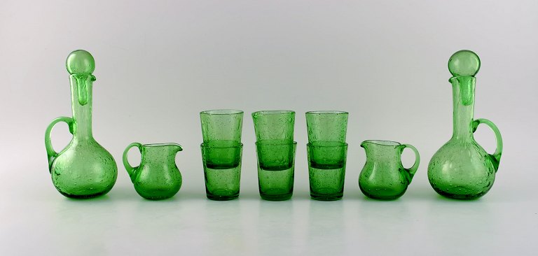 Biot, Frankrig. To karafler, seks glas og to små kander i grønt mundblæst 
kunstglas med indlagte bobler. Midt 1900-tallet.
