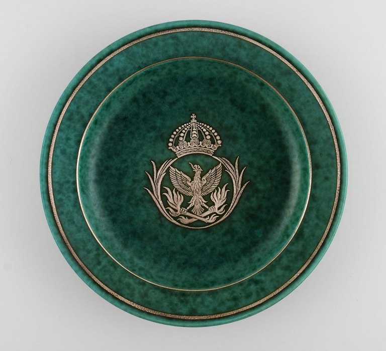 Wilhelm Kåge (1889-1960) for Gustavsberg. Argenta art deco fad i glaseret 
keramik. Smuk glasur i grønne nuancer med sølvindlæg i form af ørn og 
kongekrone. Midt 1900-tallet.
