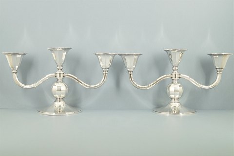 Carl M. Cohr; A pair of three armed candlesticks of hallmarked silver, 1933