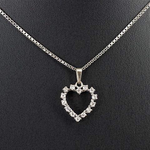A 14k white gold necklace set with a heart shaped diamond pendant