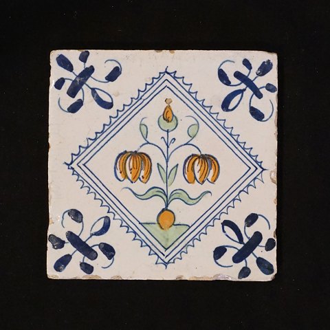 Polychromdekorierte holländische Fliese mit 
Blumenmotiv. Um 1620-40. Grösse: 13x13cm