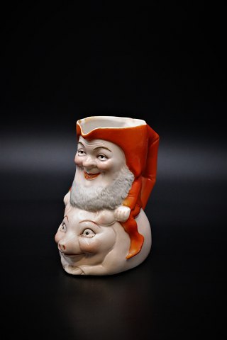 Gammel jule kande i porcelæn af nisse ridende på gris.
Højde: 11,5cm.