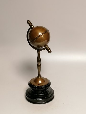 Patinated brass money box in the form of a globe 
on a wooden base