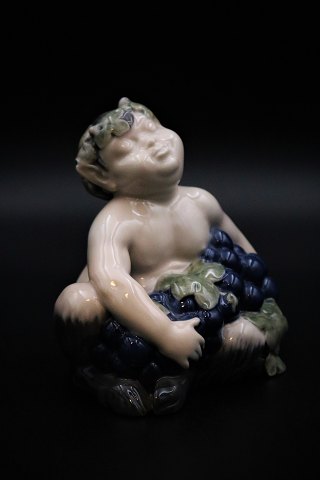 Royal Copenhagen porcelæns figur af lille pan-figur med favnen fuld af blå 
druer. RC# 2361.
Højde: 13,5cm.