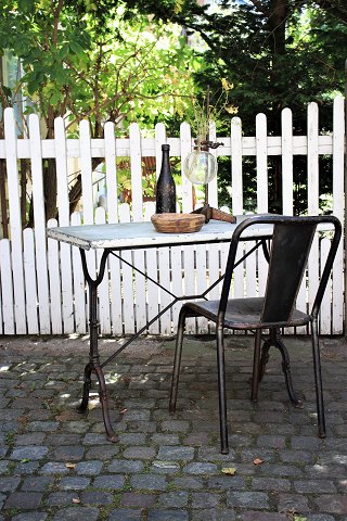 Old French bistro / café table with black cast iron base and top plate made of 
old zinc coated wood...