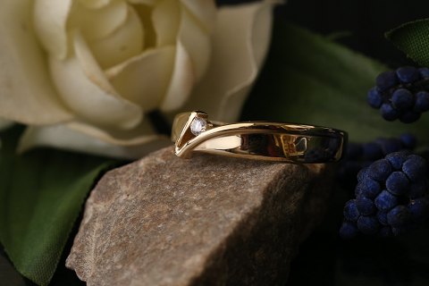 Unik guldring i 14 karat guld og hvid zirkon. Flot design og specielt look. 
Størrelse 60.