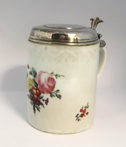 Royal Copenhagen. Lågkrus dekoreret med blomster med sølvlåg. Låg ikke stemplet. 
Højde 17 cm. Diameter 12 cm