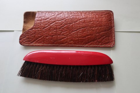 Klædebørste/fnugbørste i træ med etui i skind Lige til at have i tasken eller 
bilen
Fra midten af 1900-tallet
L: 15cm børste
L: 16cm etui