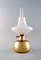 Henning Koppel (1918-81) for Louis Poulsen. "Petronella" oil lamp in brass with 
opaline glass shade.