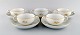 Five Meissen boullion cups with saucers in porcelain with flowers and foliage in 
relief and gold decoration. 20th century.
