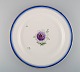 Large round antique Royal Copenhagen dish in hand-painted porcelain with flowers 
and blue edge with gold. Model number 592/9042. Late 19th century.
