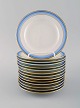 14 Royal Copenhagen tallerkener i håndmalet porcelæn. Blå kant med guld. Midt 
1900-tallet.
