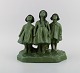 L'Art præsenterer: Alice Nordin for Ipsens Enke. Stor skulptur i jadegrøn glaseret keramik. Tre piger spejder ...