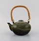 Chinese teapot in glazed stoneware with wicker handle. Beautiful speckled glaze 
in dark green and turquoise shades. 20th century.
