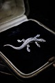 K&Co. præsenterer: Gammel broche i sølv i form af salamander med masser af små skinnende magasiter. Måler: L:5cm.