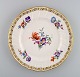 KPM, Berlin. Stor antik tallerken i svejfet porcelæn med håndmalede blomster og 
gulddekoration. Sent 1800-tallet.
