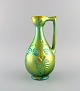 Zsolnay jug in glazed ceramics modeled with foliage. Beautiful eosin glaze. 
1960s.
