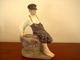 Royal Copenhagen has produced this large figurine of a Boy sitting on a rock. 
Decoration No. 1659