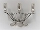 Lundin Antique 
præsenterer: 
Evald 
Nielsen. 
3-armet sølv 
lysestage. 
Højde 17,5 cm. 
Længde 25 cm. 
Produceret 
1949.