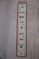 Pakkekalender
Smuk, gammel, håndbroderet pakkekalender med ringe til at binde pakkerne fast i
Flot håndarbejde
H: 90cm, B: 16cm
God stand
Antikt, dansk linned og olmerdug er vores speciale, og vi har altid et bredt 
udvalg