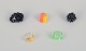 Fransk smykkekunstner. Fem designerringe i plast og metal. Stribet design med 
forskellige farver samt sorte perler.