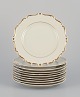 KPM, Poland. A set of ten cream-colored porcelain plates with gold decoration.