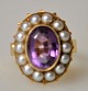 Pegasus – Kunst 
- Antik - 
Design 
presents: 
Finger 
ring in red 
gold, 14 k, 
with 14 pearls 
and amethyst.