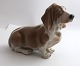 Lundin Antique 
præsenterer: 

Royal 
Copenhagen. 
Porcelænsfigur. 
Basset hund. 
Model 356. 
Længde 17 cm. ( 
2 sortering )