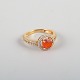 L'Art 
præsenterer: 

14 karat 
guldring prydet 
med orange opal 
og talrige 
brillianter.