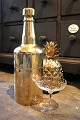 K&Co. 
præsenterer: 

Gammel 
champagnekøler 
i form af stor 
flaske i 
messing som kan 
åbnes og fyldes 
med 
isterninger...