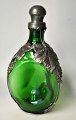 Pegasus – Kunst 
- Antik - 
Design 
presents: 
Art deco 
triangular 
green bottle 
with pewter 
mounting, 
1930s, Denmark.