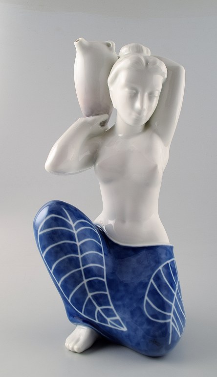 Royal Copenhagen large porcelain figurine. Semi-nude woman carrying a jar of 
water. By Johannes Hedegaard.