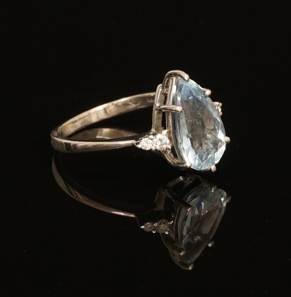 18kt hvidguld ring med akvamarin flankeret af fire diamanter. Ringstr. 56