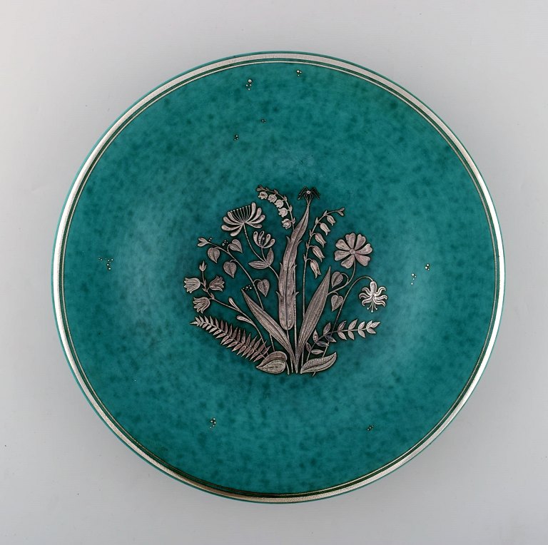 Wilhelm Kåge for Gustavsberg. Stort Argenta fad i keramik dekoreret med blomster 
i sølvindlæg.