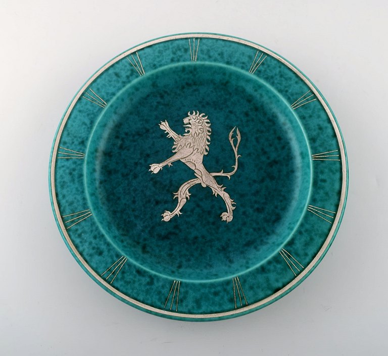 Wilhelm Kåge, Gustavsberg, art deco Argenta fad på fødder i keramik dekoreret 
med løve i sølvindlæg.