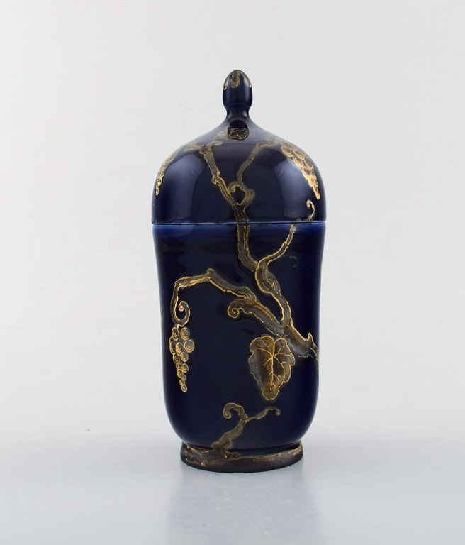 Karl Lindström and Nils Emil Lundström for Rörstrand. Lidded porcelain jar 
decorated with grape vines in gold on beautiful dark blue base. Japanism, ca. 
1920.