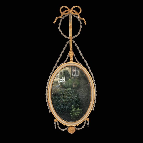 Ovalt Louis XVI spejl af "Liselund"-typen. Rigt udskåret med bl.a. guirlander og sløjfe. Delvist forgyldt. Danmark ca. år 1790. H: 116cm. B: 47cm