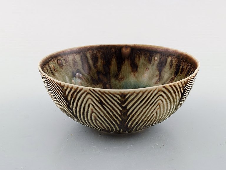 Axel Salto (1889-1961) for Royal Copenhagen. Bowl of glazed stoneware in fluted 
style. Beautiful glaze in brown and light shades. Model Number 20725. 1930/40