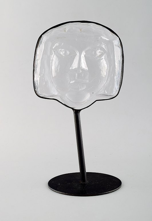 Erik Höglund for Kosta Boda, skulptur i form af ansigt i kunstglas med stander i 
smedejern. Ca. 1970.
