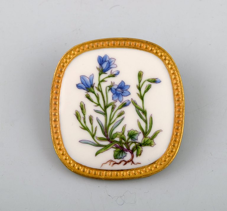 Michelsen for Royal Copenhagen. "Flora Danica" broche / vedhæng i  porcelæn og 
sterlingsølv dekoreret i farver og guld med håndmalede blomster.
