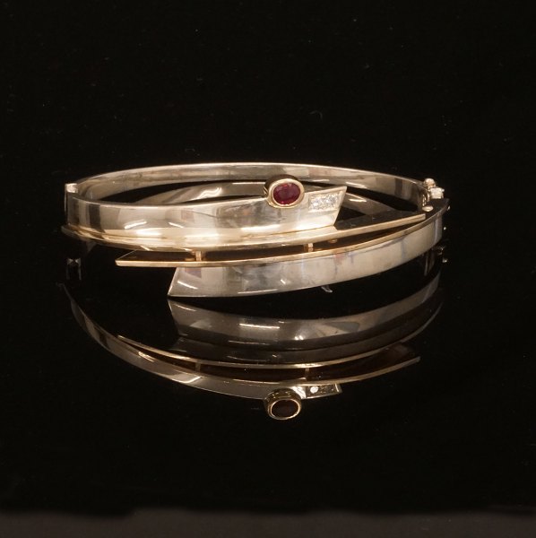 Armring in 14kt Gold und Sterlingsilber. Montiert mit zwei Diamanten von etwa 
0,08ct. Masse innen: 6,6x6cm