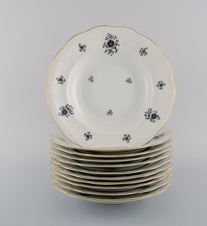 KPM, Kjøbenhavns Porcelæns Maleri. 11 Rubens dybe tallerkener i porcelæn med 
blomstermotiver, guldkant og snirkler i relief. 1940