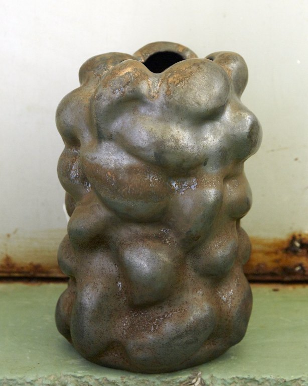 Christina Muff, dansk samtidskeramiker (f. 1971). Stor unika skulpturel vase i 
stentøj. Glasuren er en gyldenbrun kobber farve der virkelig kommer til udtryk i 
de områder hvor den er påført tykt, da
de bliver næsten metalliske.