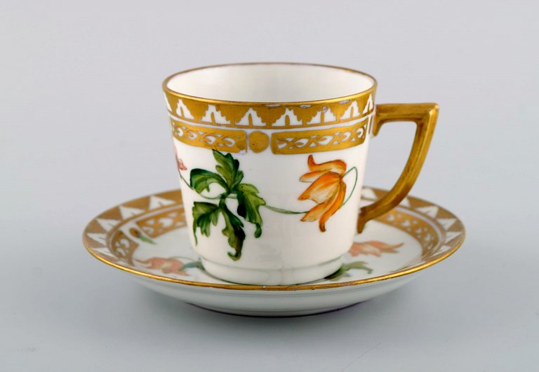 Royal Copenhagen coffee cup with saucer in hand-painted porcelain with gold 
decoration and flowers. Flora danica style, 1960s.
